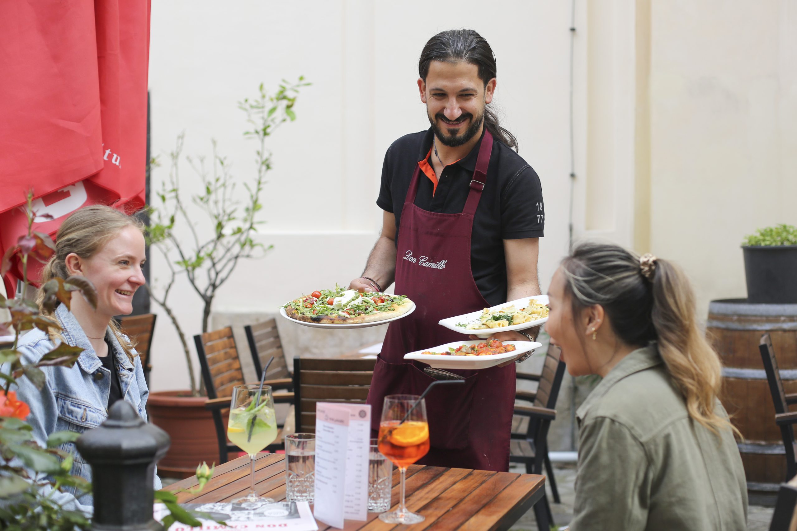Pizza wird im Gastgarten von Don Camillo in der Brückengasse serviert
