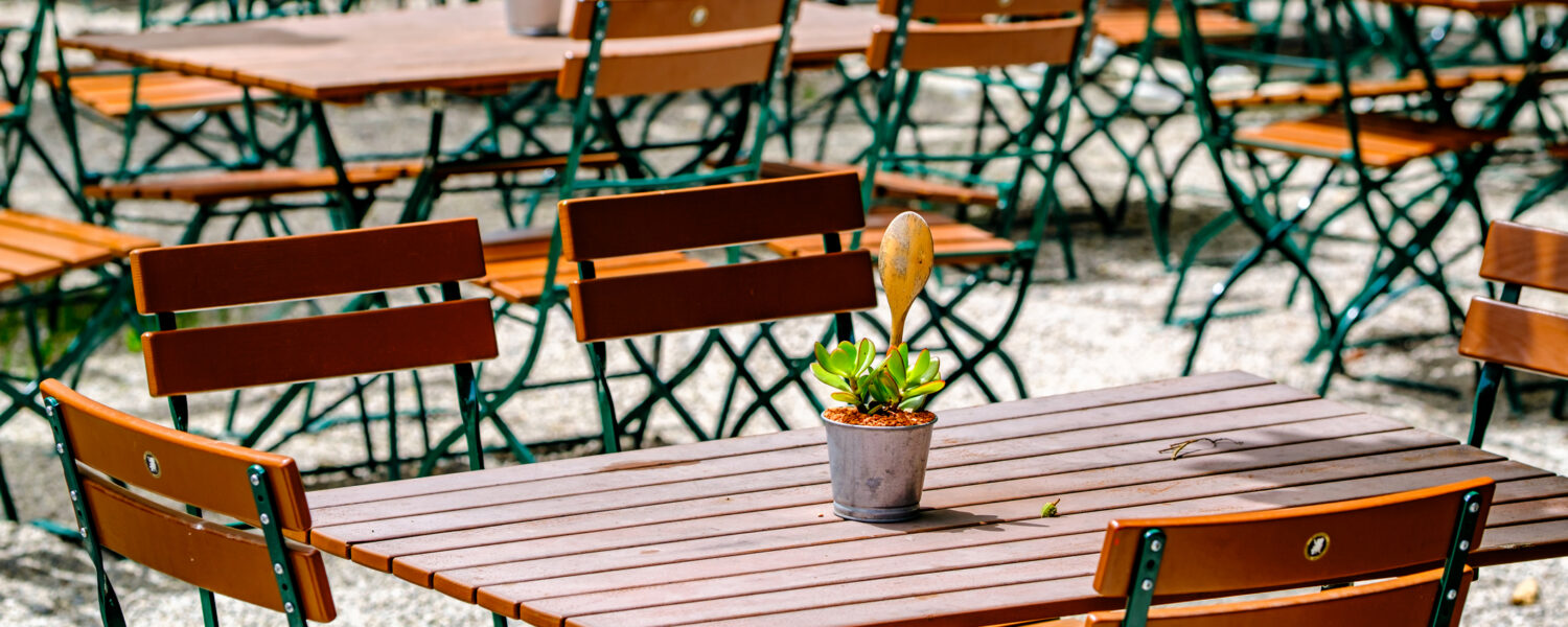 wooden benches and tables at a typical bavarian beergarden - photo
