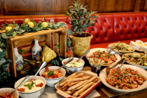 Buffet mit Bruschetta, Grissini und Aufstrichen vor roter Lederbank im Viva La Mamma in Wien